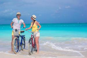 Paar Fahrrad fahren im Meerwasser foto