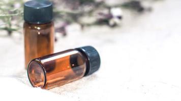 Flasche ätherisches Öl. Kräutermedizin oder Aromatherapie-Tropferflasche lokalisiert auf weißem Hintergrund. frische Rosmarinblüten und ätherische Öle auf dem Tisch foto