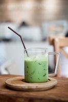 grüner Eistee Latte mit einem Strohhalm foto