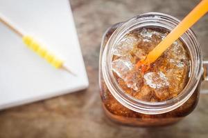 Glas Cola mit Eis auf einem Holztisch