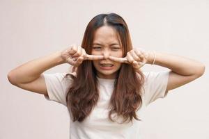 asiatische Frauen bedecken ihre Nasen mit ihren Händen, weil sie schlecht riechen. foto