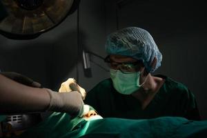 asiatisches professionelles chirurgenteam, das operationen im ops durchführt, chirurgen, assistenten und krankenschwestern, die operationen an einem patienten durchführen, gesundheitskrebs und krankheitsbehandlungskonzept foto
