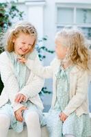 2 kleine Mädchen mit hellem Haar lachen. Liebe der Schwestern. Die Wettermädchen lieben sich sehr. pflegerische Verbindung. herzliche Beziehungen in der Familie. zartes Foto mit zwei kleinen Mädchen.