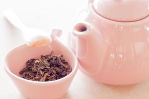 Oolong-Tee in einer Keramikschale mit Glas und Holzlöffel foto