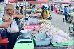 badung, bali - 13. januar 2023 gesehen, dass ein verkäufer von hühnerfleisch hühnerfleisch an den käufer verkauft foto