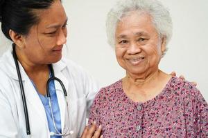 arzt hilft asiatischen älteren frauen mit behinderungspatienten im pflegekrankenhaus, medizinisches konzept. foto