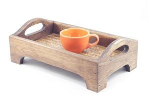 orange Kaffeetasse auf einem Holztablett foto