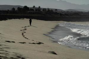 frau, die in todos santos baja california beach läuft foto