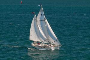 ein Boot mit einem einsamen Kapitän, der im blauen Meer segelt foto