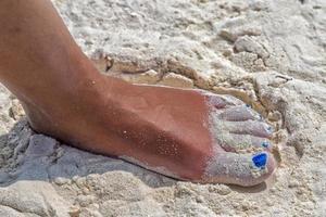 frauenfüße mit blauem nagellack am bach foto