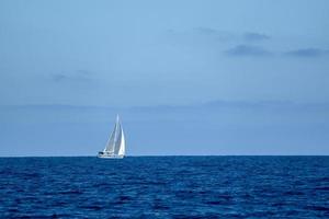 kleines segelboot auf tiefblauem meer foto