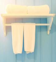 saubere weiße Handtücher auf einem Kleiderbügel