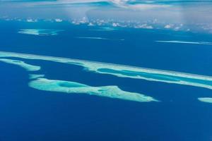 luftaufnahme des malediven-resorts, luxusreiseziel. vogelperspektive auf tiefblaues meer, korallenschilf, tropische insel. erstaunliche naturansicht, drohnenluftlandschaft foto