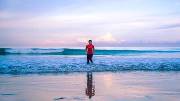 Mädchen, das morgens am Strand joggt. entspannen und glücklich mit dem Laufen auf dem Meer. im Sommer foto