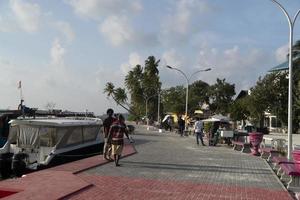 guraidhoo, malediven - märz, 4 2017 - menschen, die auf einer kleinen dorfstraße arbeiten und spazieren gehen foto