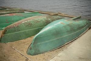 Alte Boote werden an Land umgeworfen. Bootsstation. Boote trocknen aus. foto