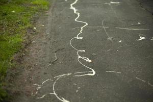 malen auf Asphalt. Spritzer weißer Farbe auf der Straße. verschmutzte Oberfläche. foto