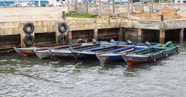 sechs kleine hölzerne Fischerboote, die am Pier anlegen. foto