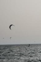 Windsurfen, Kitesurfen, Wasser- und Windsport mit Segeln oder Drachen foto