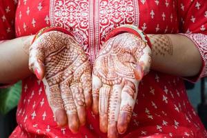 schöne frau, die sich als indische tradition mit henna-mehndi-design an beiden händen verkleidet hat, um das große fest von karwa chauth zu feiern, karwa chauth-feiern der indischen frau für ihren ehemann foto