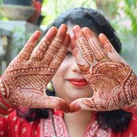 schöne frau, die sich als indische tradition mit henna-mehndi-design an beiden händen verkleidet hat, um das große fest von karwa chauth zu feiern, karwa chauth-feiern der indischen frau für ihren ehemann foto