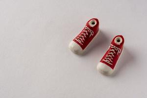 ein paar rote schuhe turnschuhe auf weißem hintergrund, kreative komposition. Spielzeug Turnschuhe auf weißem Hintergrund foto