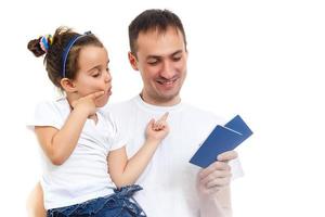 lächelnde Eltern mit Pässen und Tickets und Tochter, isoliert auf weiss foto