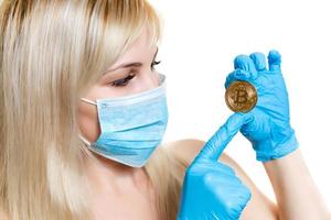 Nahaufnahmeporträt eines jungen Arztes, der eine Maske trägt, die auf weißem Hintergrund Bitcoin isoliert ist foto