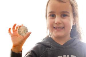 goldenes Bitcoin in einem digitalen Symbol der Kinderhand eines neuen selektiven Fokus der virtuellen Währung foto