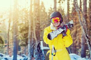 Winterporträt eines schönen Mädchens mit Sonnenbrille. Skifahrer im Wald. Nahaufnahme foto