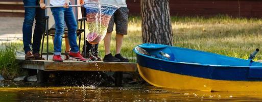 kleiner Junge und Mädchen, die in einem Fluss angeln. sitzt auf einem Holzsteg foto