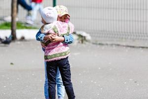 Zwei entzückende kleine Schwestern lachen und umarmen sich foto