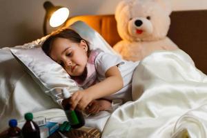 kleines Mädchen mit Krankheit auf dem Bett foto