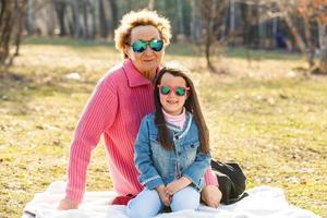 kleines Mädchen und ihre Großmutter mit Sonnenbrille im Freien