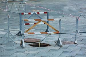 Offenes ungesichertes Kanalschachtloch auf der Stadtstraße foto