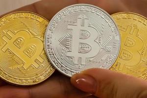 hand hält drei münzen der digitalen währung bitcoin foto