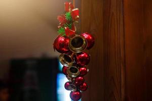 weihnachtsdekoration zweig weihnachtsbaum weihnachtsglocken rote und gelbe kugeln rote beeren und foto