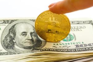 bitcoin in weiblicher hand auf dollarbanknotenhintergrundnahaufnahme foto