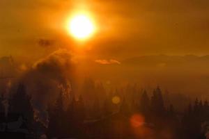 Bunter Herbstmorgen in den Karpaten. Dramatischer Sonnenaufgang im Bergdorf. nachbearbeitetes Foto im künstlerischen Stil.