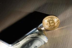 konzept mit geld, us-dollar, bitcoin und handy foto