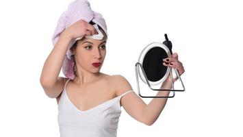 Frau, die Make-up mit einer nassen Serviette von ihrem Gesicht entfernt foto