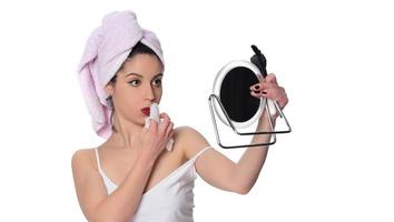 Frau, die Make-up mit einer nassen Serviette von ihrem Gesicht entfernt foto