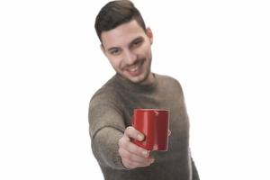 Mann hält eine Kaffeetasse isoliert auf weißem Hintergrund foto