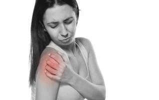 Schwarz-Weiß-Foto einer Frau mit Schmerzen in der Schulter foto