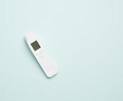 Kunststoff weißes elektronisches berührungsloses Thermometer, blauer Hintergrund foto