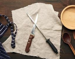 Scharfes Messer und Spitzer mit Griff auf Holzhintergrund foto