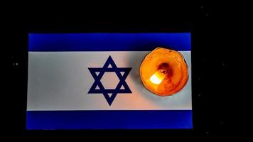 israelische flagge und kerzen, die darüber brennen, holocaust-gedächtnistag foto