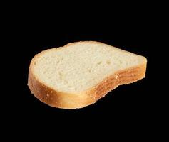 frische ovale Brotscheibe aus weißem Weizenmehl isoliert auf schwarzem Hintergrund foto