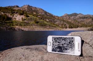 kaputtes Telefon auf den Felsen foto