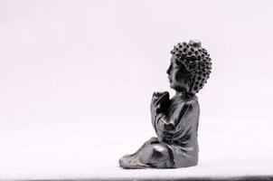 Buddha-Miniatur auf weißem Hintergrund foto